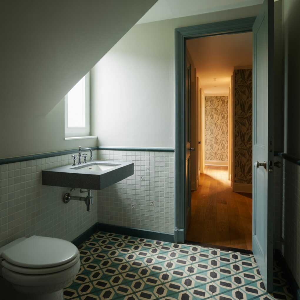 Under Stairs Powder Room with a Geometric Floor