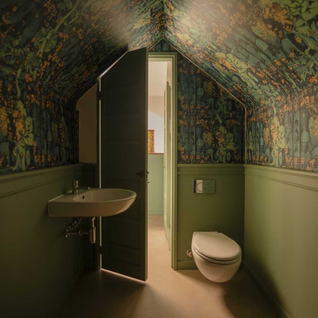 Under Stairs Powder Room with a Wallpapered Ceiling